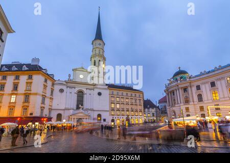 Weihnachtsmarkt Stände und St. Michael Katholische Kirche in Michaelerplatz, Wien, Österreich, Europa Stockfoto