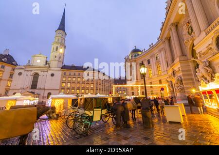 Weihnachtsmarkt Stände und St. Michael Katholische Kirche in Michaelerplatz, Wien, Österreich, Europa Stockfoto