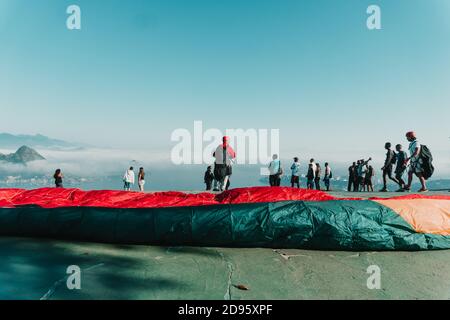 RIO DE JANEIRO, BRASILIEN - 27. Okt 2020: Wunderschöne Landschaftsaufnahme von Menschen, die sich zum Fallschirmspringen in Rio de Janeiro mit herrlichem blauen Himmel vorbereiten. Stockfoto