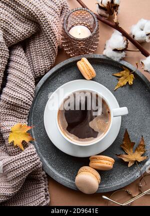 Schöne und romantische Herbstkomposition mit Tasse Kaffee, warmer Decke, dekorativ gestreiften Kürbissen, Kerzen und Herbstblättern. Gemütlicher Morgen. Hyg Stockfoto