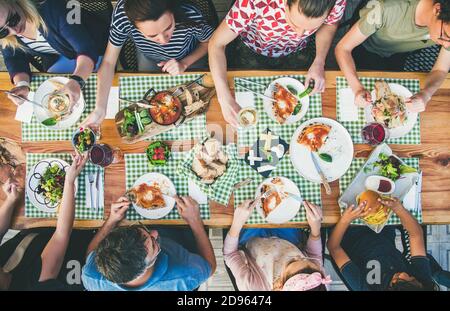 Familie oder Freunde Sommerparty oder Abendessen im Freien. Flat-Lay der Gruppe von Menschen an einem großen Tisch im Café essen Verious Essen zusammen. Sommer Treffen oder Feier Konzept Stockfoto