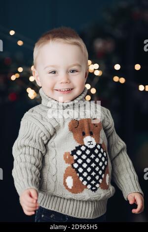 Süßer Junge im Teddybär Pullover an Weihnachten. Stockfoto