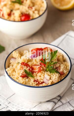 Tabouleh ist ein arabisch-vegetarischer Salat mit Couscous, Tomaten, Petersilie. Gesundes Mittagessen Stockfoto