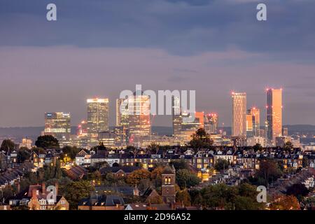 Großbritannien, England, London, Blick auf die Skyline von Muswell Hill in der Innenstadt von London mit Vorstadtwohnungen in Crouch End und der Canary Wharf CBD in Docklands, Abenddämmerung Stockfoto