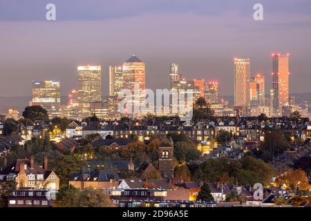 Großbritannien, England, London, Blick auf die Skyline von Muswell Hill in der Innenstadt von London mit Vorstadtwohnungen in Crouch End und der Canary Wharf CBD in Docklands, Abenddämmerung Stockfoto