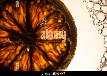 Eine Scheibe Orange in einem Wasser mit Blasen Stockfoto