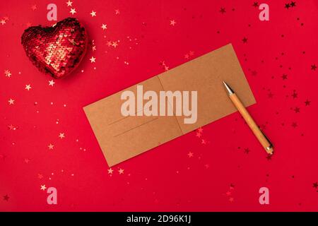 Schreiben eines weihnachtsbriefes mit Gratulation oder Gratulation, Stift und Dekorationen auf roter Oberfläche. Frohe Weihnachten Happy New Year Konzept Stockfoto