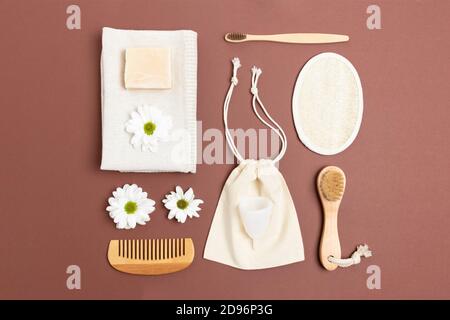 Layout der weißen Kamille, Leinwandsack, Zubehör für die persönliche Hygiene. Keine Abfallzusammensetzung auf braunem Hintergrund. Stockfoto