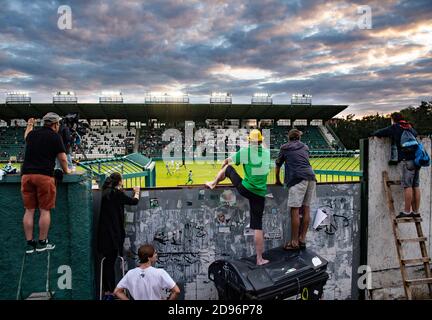 Fans, die hinter dem Zaun auf Leitern stehen, beobachten ein tschechisches Match der ersten Division zwischen den Bohemians Prag und Mlada Boleslav in Prag, Czech Repub Stockfoto