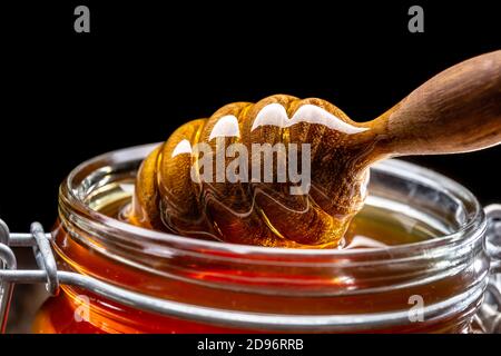 Glas Honig mit Dipper Nahaufnahme - Studio erschossen Stockfoto