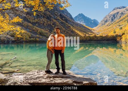 Glückliches Paar am Kristallsee in den herbstlichen Bergen. Bergsee und paar Wanderer Stockfoto