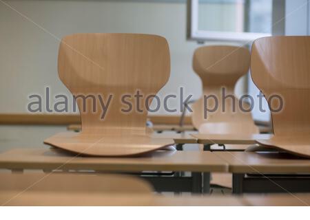 Schulstühle an Schultischen in einem verlassenen Klassenzimmer in Bayern, Deutschland, während der Corona-Krise. Stockfoto