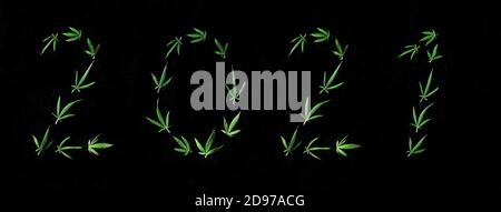 Muster von Cannabisblättern in Form von Zahlen 2021 auf einem schwarzen isolierten Hintergrund. Das Konzept eines neuen Jahres. Hintergrund der Cannabispflanze. Kopieren Stockfoto