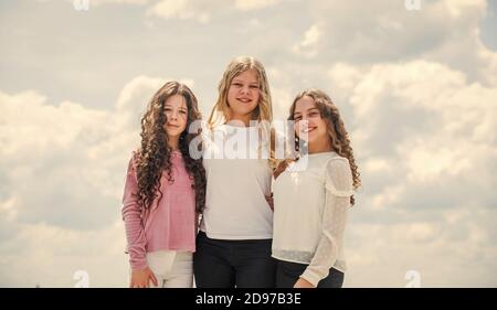 Drei Mädchen auf Himmel Hintergrund. Konzept der weiblichen Freundschaft. schwesternschaft und Familie. Beste Freunde zusammen in der Schule. Zurück zur Schule. Glückliche Kindheit. Fröhliche kleine Kinder. Stockfoto