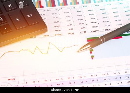 Die Arbeit eines Buchhalters, Analysten oder Bankiers mit statistischen Indikatoren. Büroarbeitstisch mit Taschenrechner, Stift, Graphen und Tabellen mit Zahlen Stockfoto