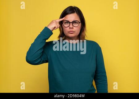 Hübsche Frau in Brille suchen mit nachdenklichen Blick machen Plan Für morgen Stockfoto