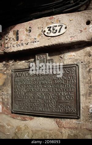 Informationstafel und alte bemalte Werbeschild bei Advocate's Close an der Royal Mile, Edinburgh, Schottland. Stockfoto