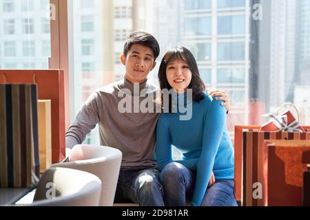 Junge asiatische Paar Ruhe und entspannend sitzen am Fenster in Hotelzimmer nach dem Einkaufen in der Stadt Stockfoto