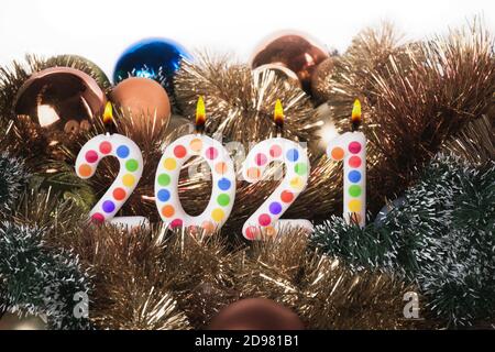 Vier bunte Kerzen schreiben Zahlen Flamme Frohes neues Jahr 2021 Stockfoto