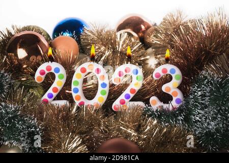 Vier bunte Kerzen schreiben Zahlen Flamme Frohes neues Jahr 2023 Stockfoto