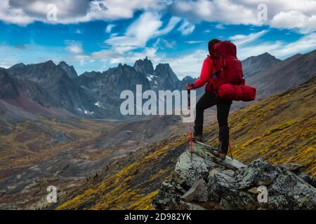 Frau auf Felsen stehend Blick auf malerische Bergspitzen und Tal Stockfoto