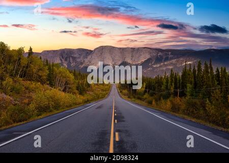 Blick auf die Scenic Road, umgeben von Bäumen und Rocky Mountains Stockfoto