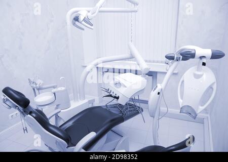 Moderne Zahnarztpraxis. Zahnstuhl und andere Accessoires von Zahnärzten in blau, Sanitäter Licht verwendet Stockfoto