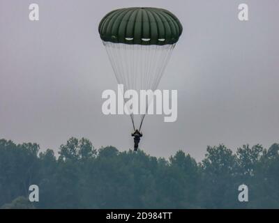 SAINTE MERE L'EGLISE, FRANKREICH - 6. JUNI 2019. Silhouetten der Armee Skydiver Team gegen dramatischen Himmel. Für die französische normandie Freiheit nach der zweiten Welt Stockfoto