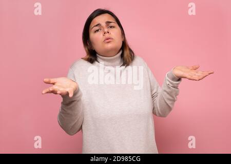 Schöne kaukasische zweifelhafte Frau zuckt mit den Schultern. Stockfoto