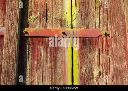 Scharniere an einer alten roten Holztür Stockfoto