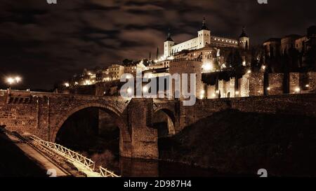 Toledo in Spanien bei Nacht. Berühmte UNESCO-Welterbestätte. Panorama der historischen Stadt mit Alcazar Festung bei Nacht. Stockfoto