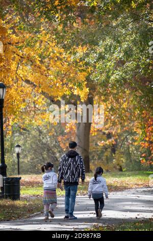 Eine Familie spaziert durch den Kissena Park inmitten der wunderschönen Herbstfarben. In Flushing, Queens, New York City. Stockfoto