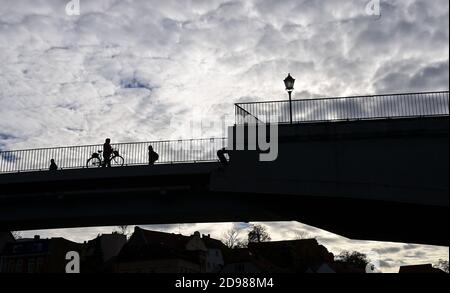 Bernburg, Deutschland. November 2020. Fußgänger und Radfahrer befinden sich auf einer Brücke über die Saale. Der Herbst ist in diesen Tagen sonnig. Quelle: Hendrik Schmidt/dpa-Zentralbild/dpa/Alamy Live News Stockfoto