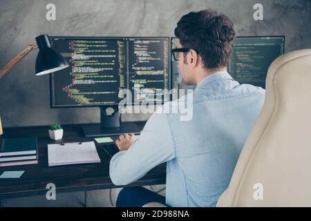 Hinten hinten hinten hinter Ansicht Porträt von seinem er nett geschickt Konzentriert beschäftigt Geek Kerl Eingabe Erstellung Datenbank-Datenbank bei Moderne industrielle Innenausstattung Stockfoto