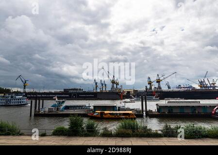 Hamburg, Deutschland - 16. August 2019: Hafen an der Elbe mit Kräne, Kreuzfahrtschiff und Dampfschiff mit Menschen in Hamburg, Deutschland Stockfoto