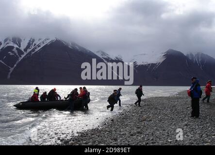 Passagiere von Kreuzfahrtschiffen, die an Land fahren, um die alten Walfangstationen, Minen, Flore und Fauna auf den Inseln der hohen Arktis zu erkunden. Stockfoto
