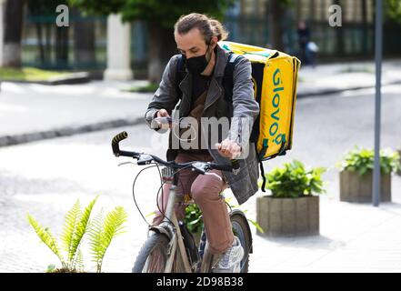 Lviv, Ukraine - 25. Mai 2020: Ein Glovo-Kurier liefert Lebensmittel in Lviv, Ukraine. Stockfoto