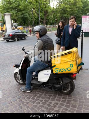 Lviv, Ukraine - 25. Mai 2020: Ein Glovo-Kurier liefert Lebensmittel in Lviv, Ukraine. Stockfoto