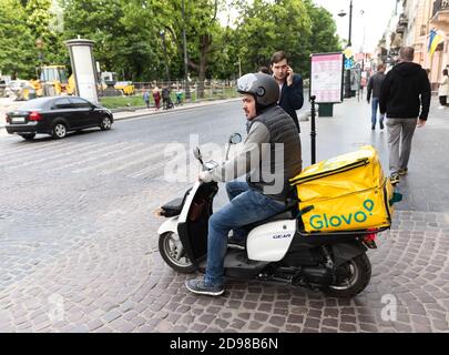 Lviv, Ukraine - 25. Mai 2020: Ein Glovo-Kurier liefert Lebensmittel in Lviv, Ukraine. Stockfoto