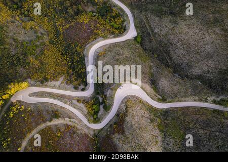 Schöne Drohne Luftaufnahme von oben der Straße mit Kurven in Berglandschaft mit einem Van soziale Distanzierung in der Nähe von Piodao, Serra da Estrela in Portugal Stockfoto