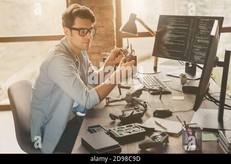 Profil Seitenansicht Porträt von seinem er schön attraktiv zuversichtlich Fokussierter Kerl Tech-Spezialist erfinden Reparatur Luft Drohne Home-based Studio Modern Stockfoto