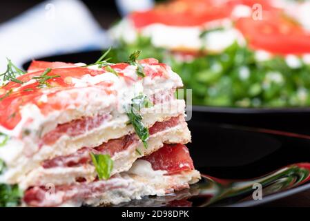 Nahaufnahme eines Stückes Zucchini Puff Pie auf einem schwarzen Teller mit Reflexion. Food Background Konzept. Stockfoto