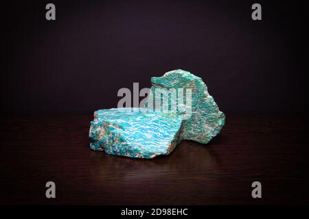 Zwei Stücke von schönen hellen semiprecious Mineral Amazonit liegen auf Eine hölzerne Oberfläche Stockfoto