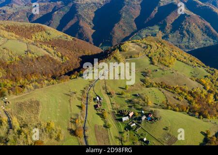 Luftaufnahme der epischen Landstraße und Herbstwald von oben, Drohne Sicht Stockfoto