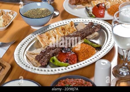 schisch-Fleischbällchen aus der türkischen Küche. Serviert mit weißem Teller auf Holztisch. Stockfoto