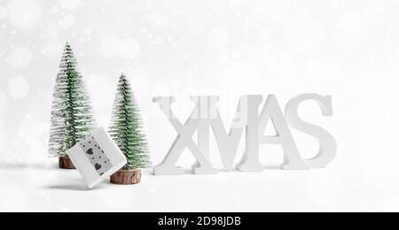 Weihnachten Urlaub Hintergrund. Nahaufnahme Weihnachtsdekorationen weiße Buchstaben XMAS, Xmas Bäume, DIY Geschenkbox auf weiß. Stockfoto