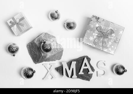 Weihnachten trendige monochrome Anordnung von Weihnachten silber und weiß Dekorationen auf Steinständer und auf weiß. Draufsicht. Stockfoto