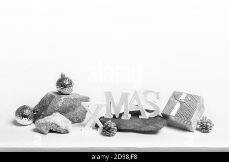 Weihnachten trendy kreative minimal monochrom Komposition. Weihnachten Dekorationen auf Stein steht auf weiß mit Kopierraum. Stockfoto