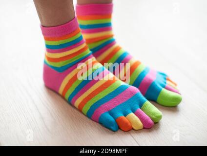 Nahaufnahme von Frau tragen Bunte Socken an den Füßen stehend auf Holzboden Stockfoto