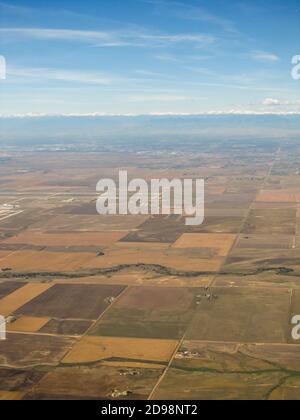 Luftaufnahme über die Farmen etwas außerhalb von Denver, Colorado, mit den schneebedeckten Rocky Mountains im Hintergrund Stockfoto